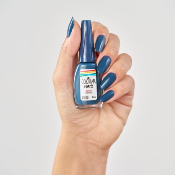 Mão segurando o esmalte Jeans da Coleção Colorama Retrô.