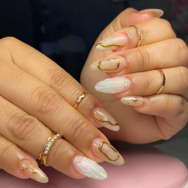 press-on-nails-dourado Mãos com press on nails com nail art dourada nas unhas.