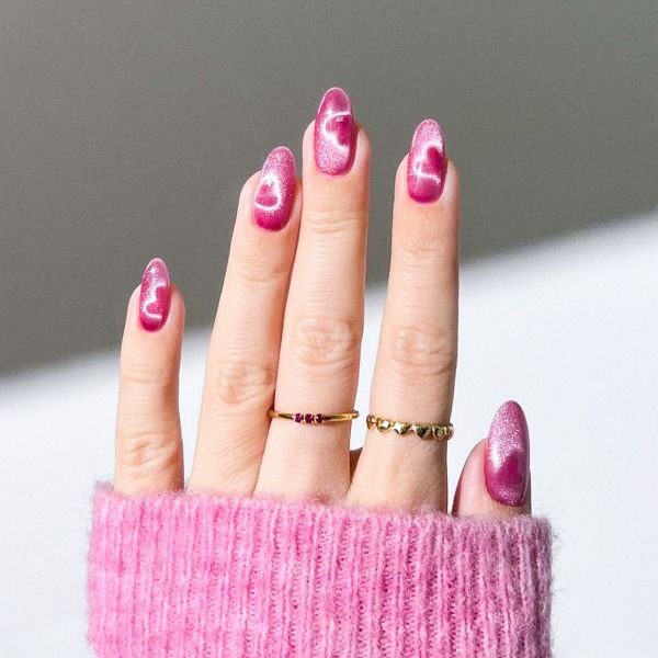 press-on-nails-unha-encapsulada Mão com press on nails com unha encapsulada em tom rosa pink e dois anéis no dedo do meio e dedo anelar